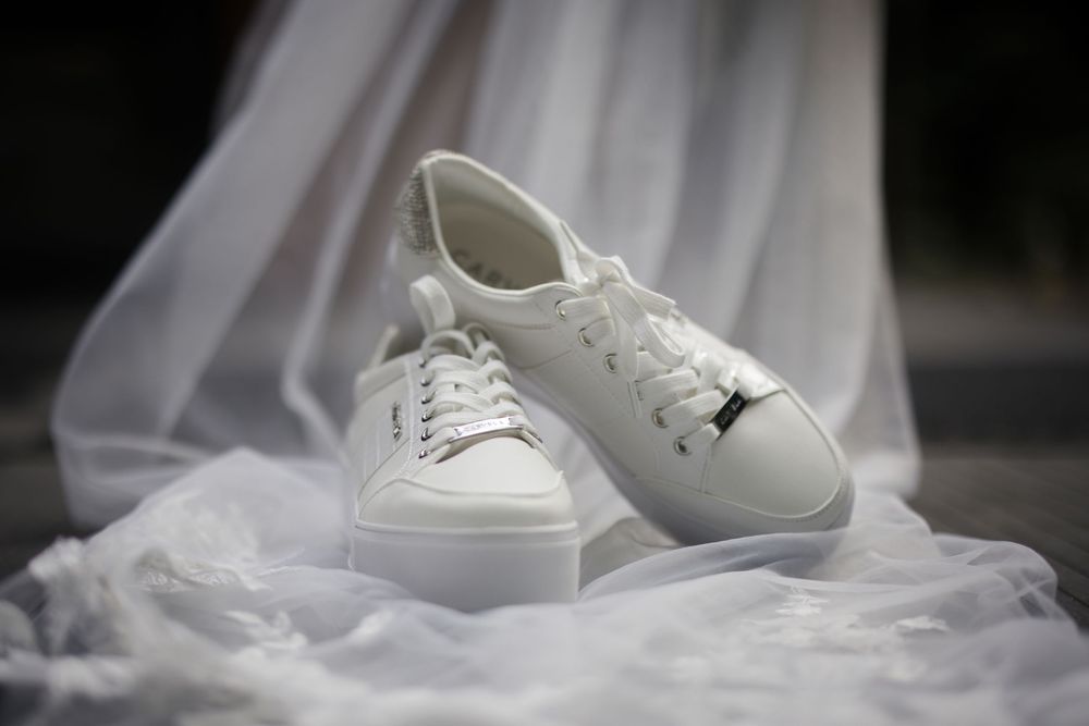 White wedding shoes displayed against a soft, ethereal background.