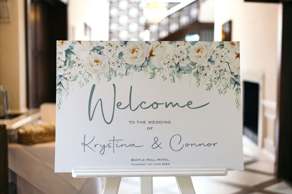 Wedding welcome sign with floral design and modern calligraphy.