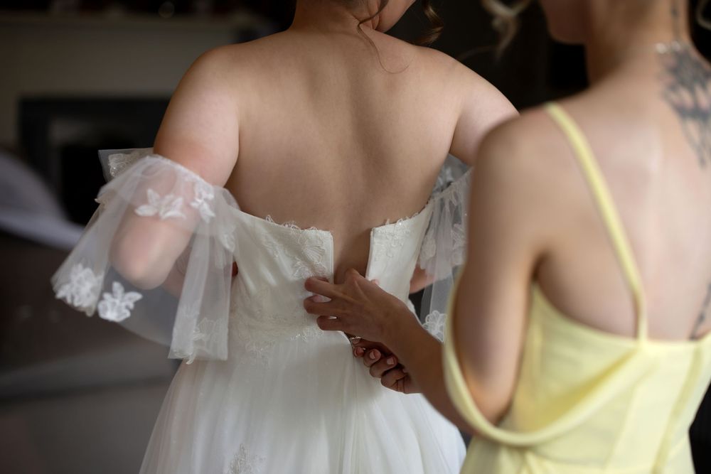 Bridesmaids in pale yellow dresses stand together during a wedding celebration.