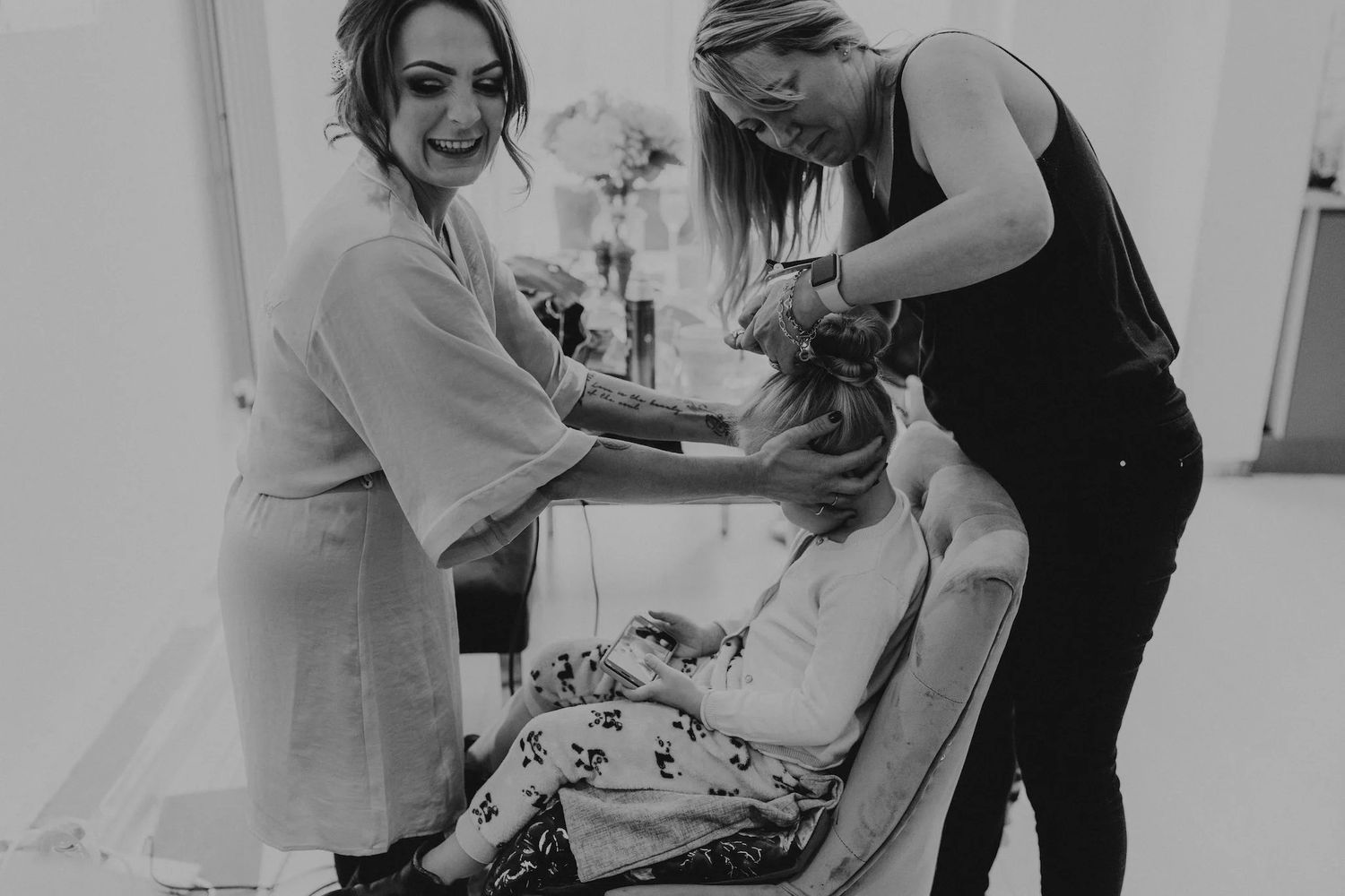 Healthcare workers assist a patient during a medical procedure in a black and white photograph.