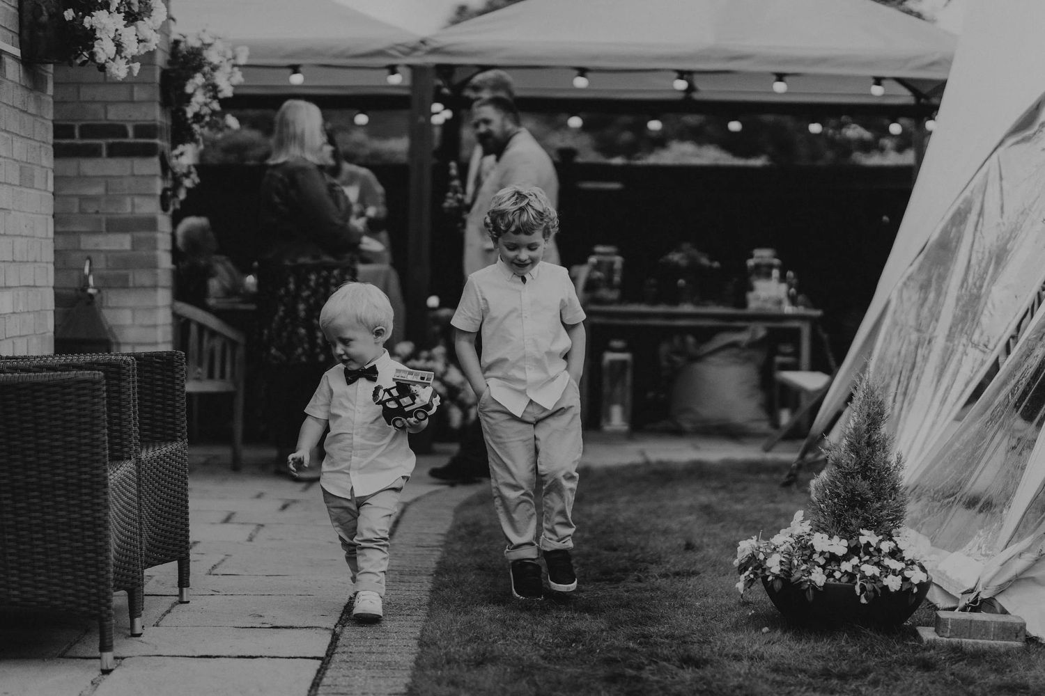 A collection of candid black and white wedding photos showing guests mingling and celebrating outdoors.