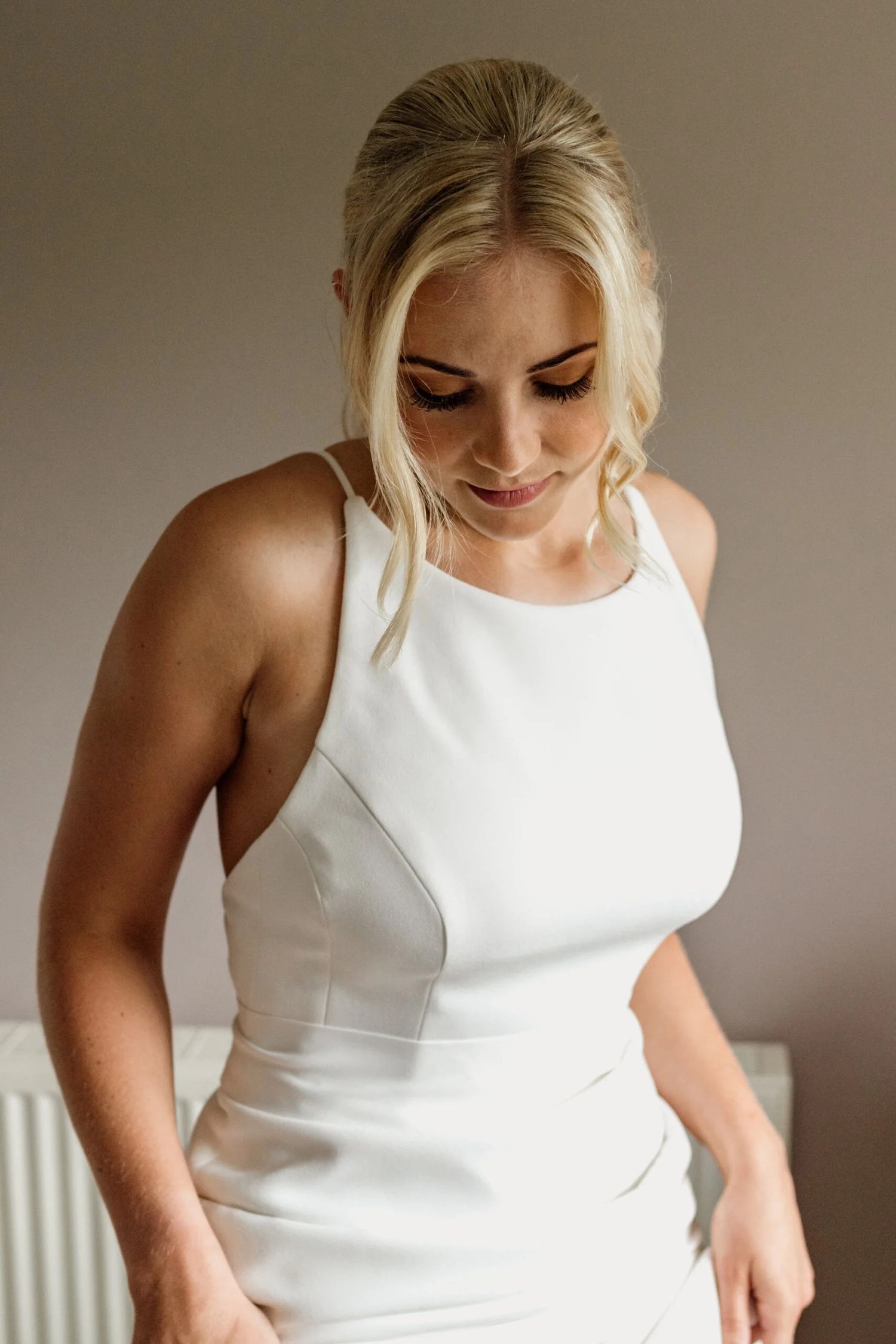 Close-up series of a person in a white sleeveless dress looking down at details.