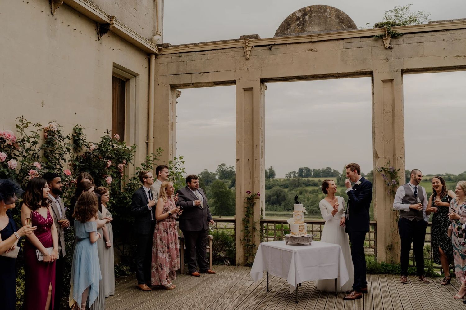 Elegant outdoor wedding ceremony setup with stone columns and natural landscape views in the background.