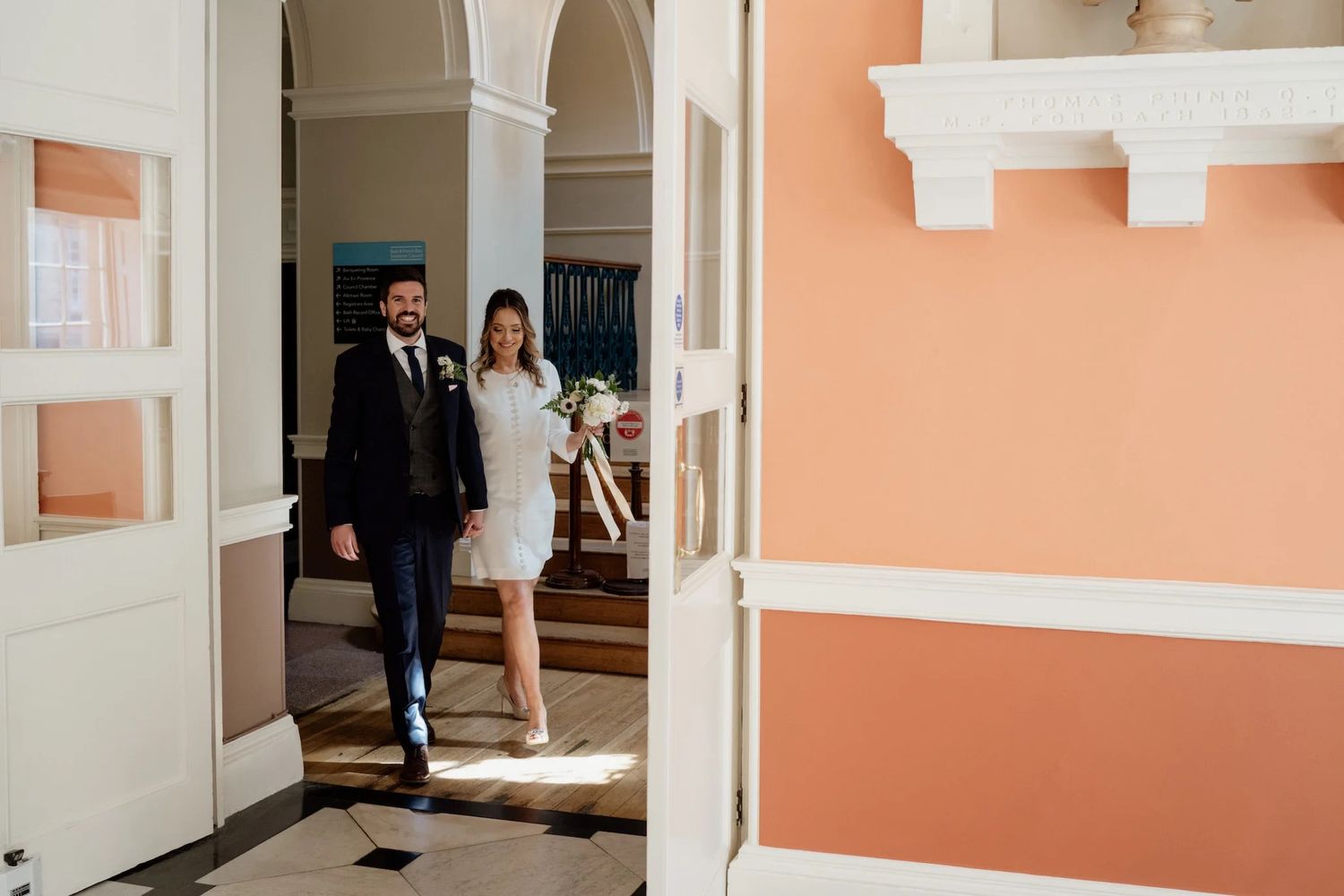 Light-filled hallway with peach walls and classic white trim details.