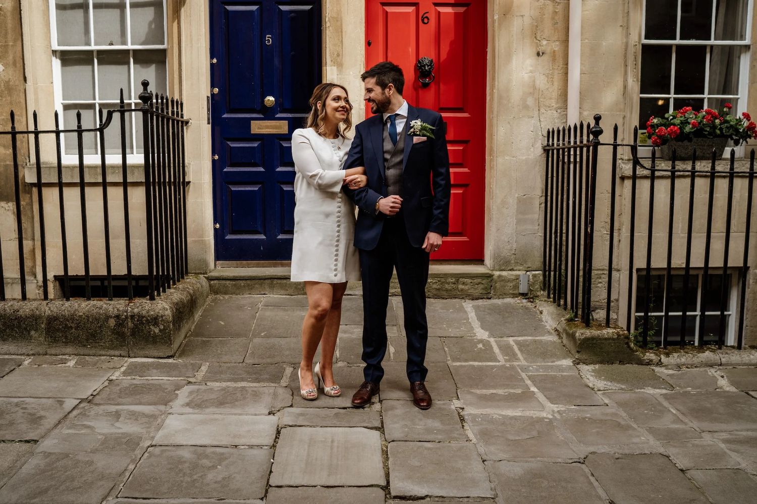 Row of colorful Georgian townhouses with blue and red doors along an elegant street in London.