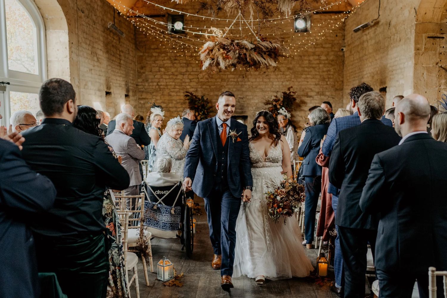 Reception venue features stunning stone architecture with dramatic lighting and high ceilings.