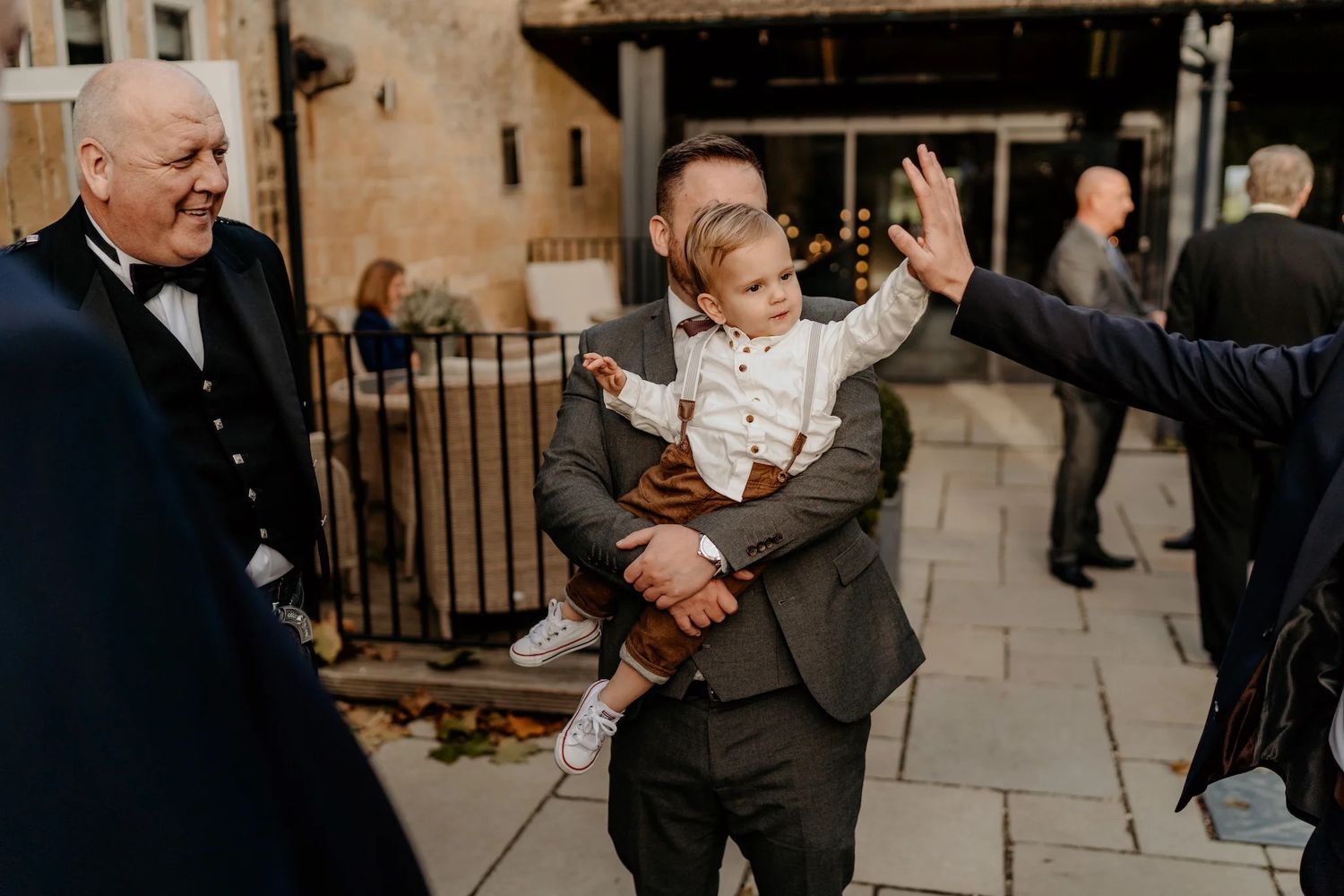 Wedding party mingles and celebrates in a rustic stone venue with vaulted ceilings.