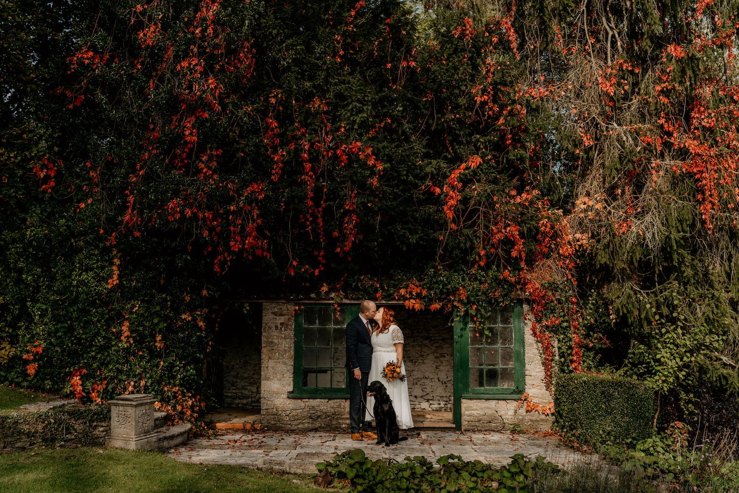Autumn wedding ceremony at a rustic venue with red berries and natural foliage.