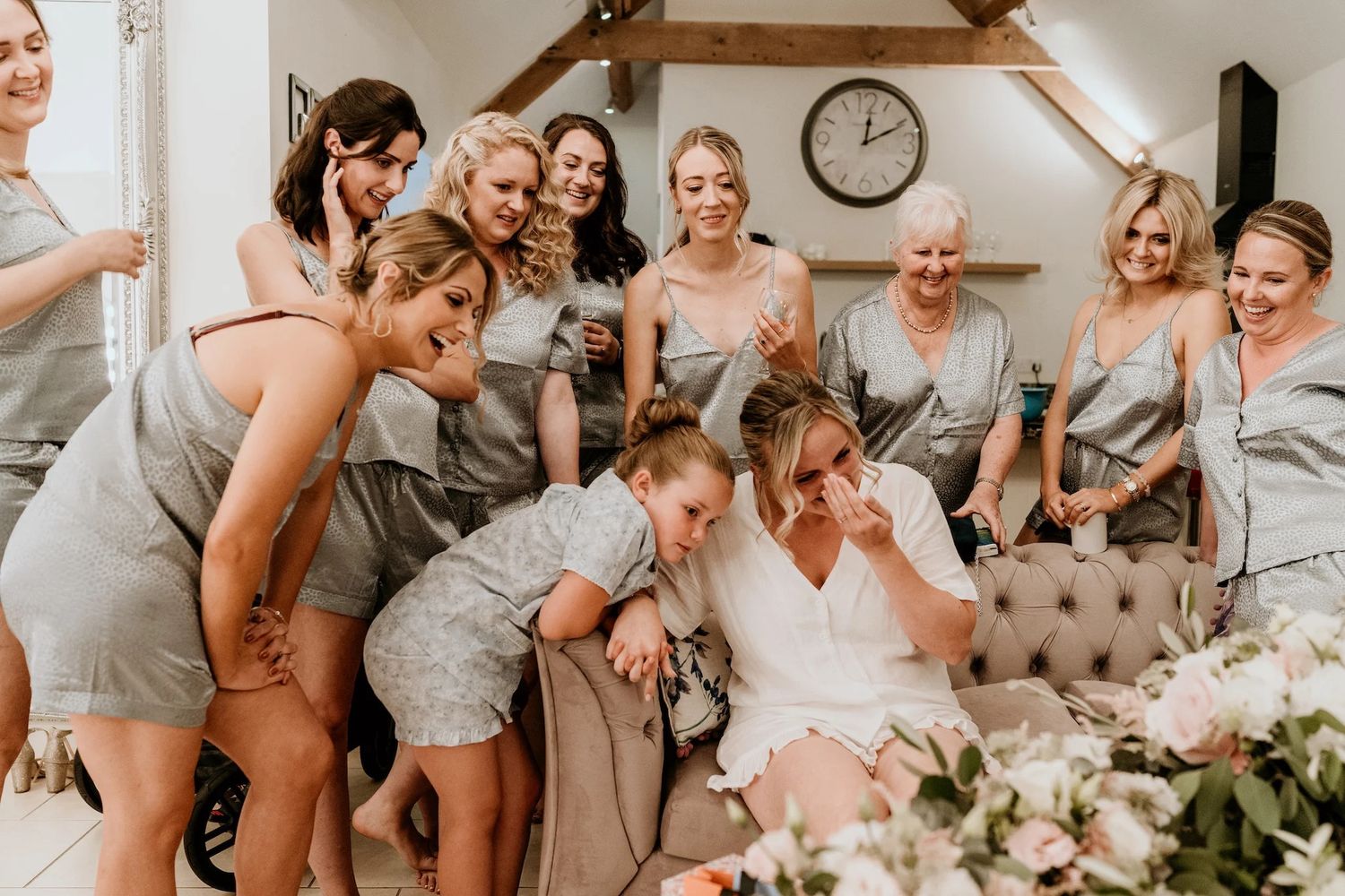 Bridal party sharing joyful laughter and embraces while getting ready.
