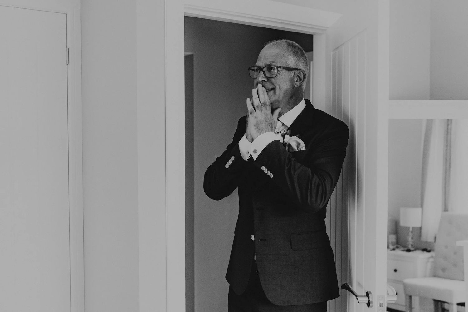 Classic black and white wedding day getting ready moments in a bright room.