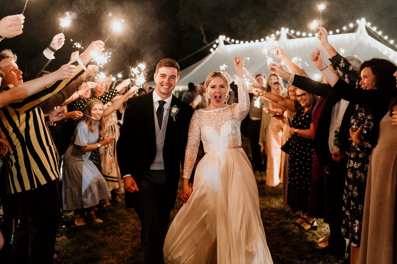 Evening wedding reception with string lights creating a magical outdoor atmosphere.