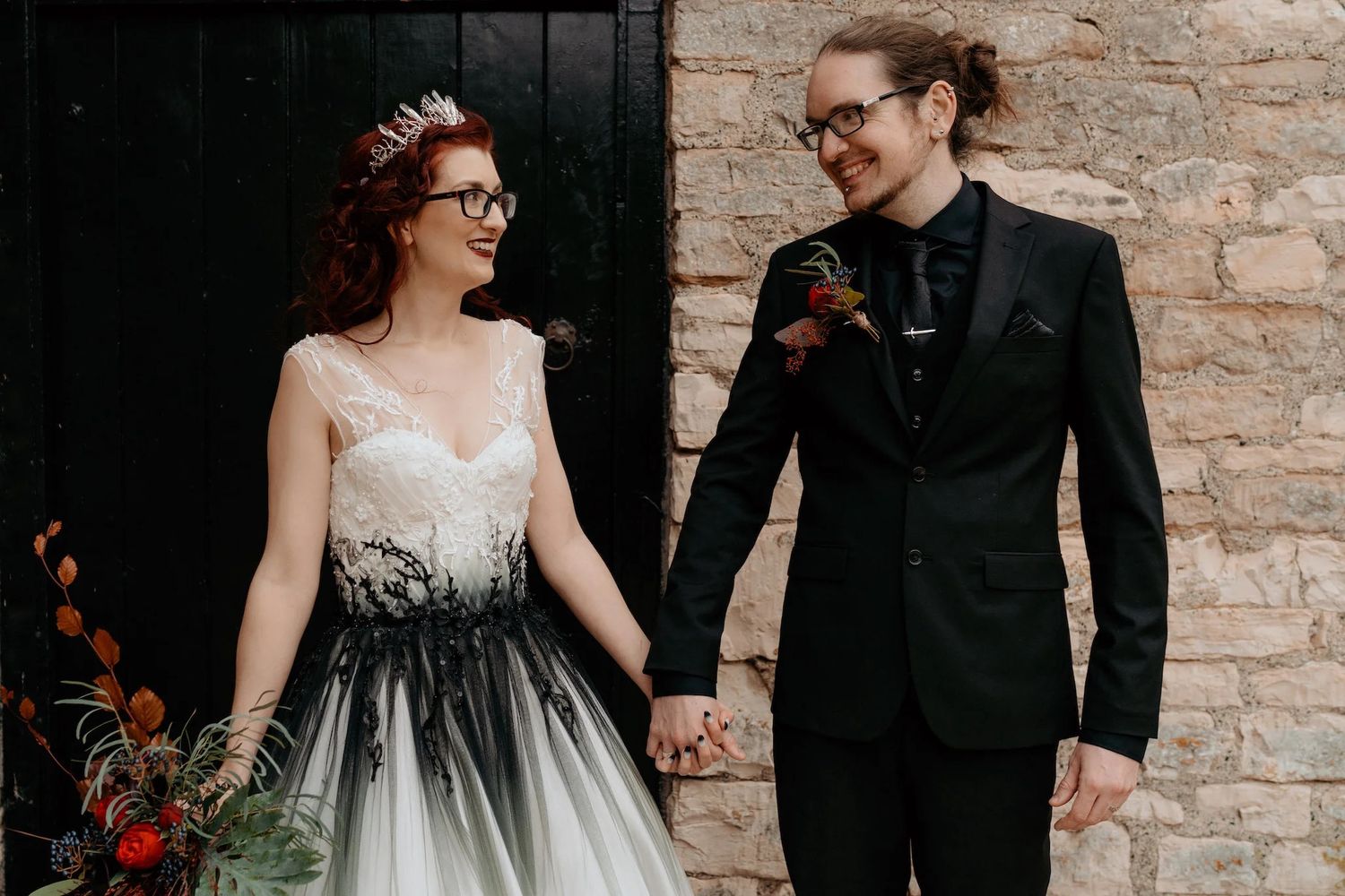 Wedding couple portraits showing close-up details of formal attire against stone wall backdrop.