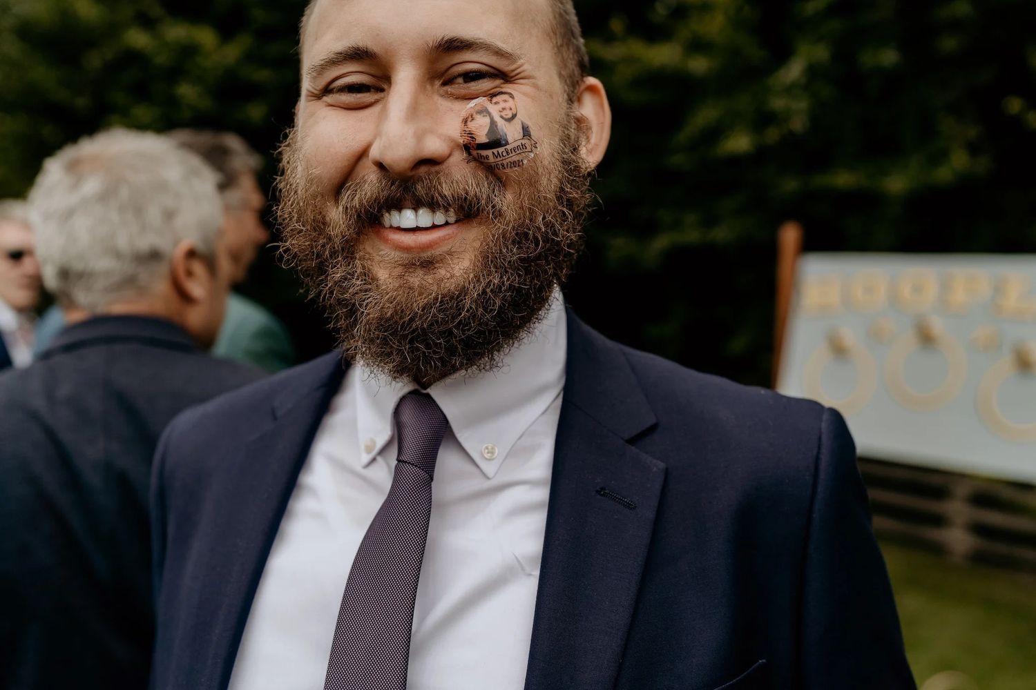 Individuals in formal attire share joyful expressions at an outdoor event.