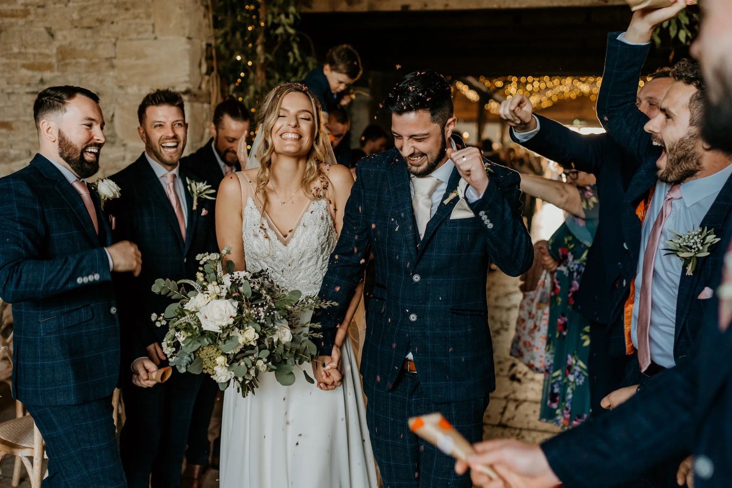Wedding party lined up outdoors in navy suits and formal attire during an elegant celebration.