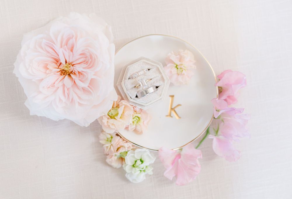 Soft pink roses and white candles create an elegant romantic display on a light background.