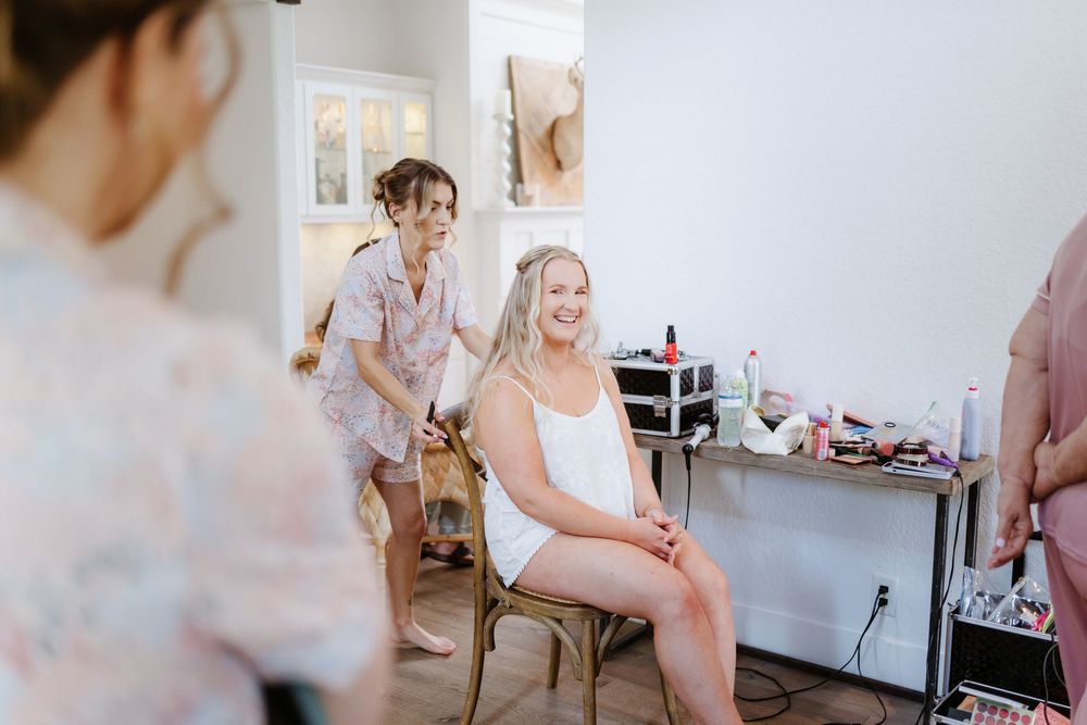 Wedding party preparations taking place in a bright indoor room with elegant decor.