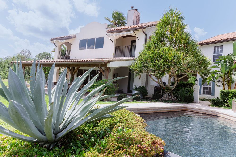 Mediterranean style house with a swimming pool and large agave plant in the landscaped garden.