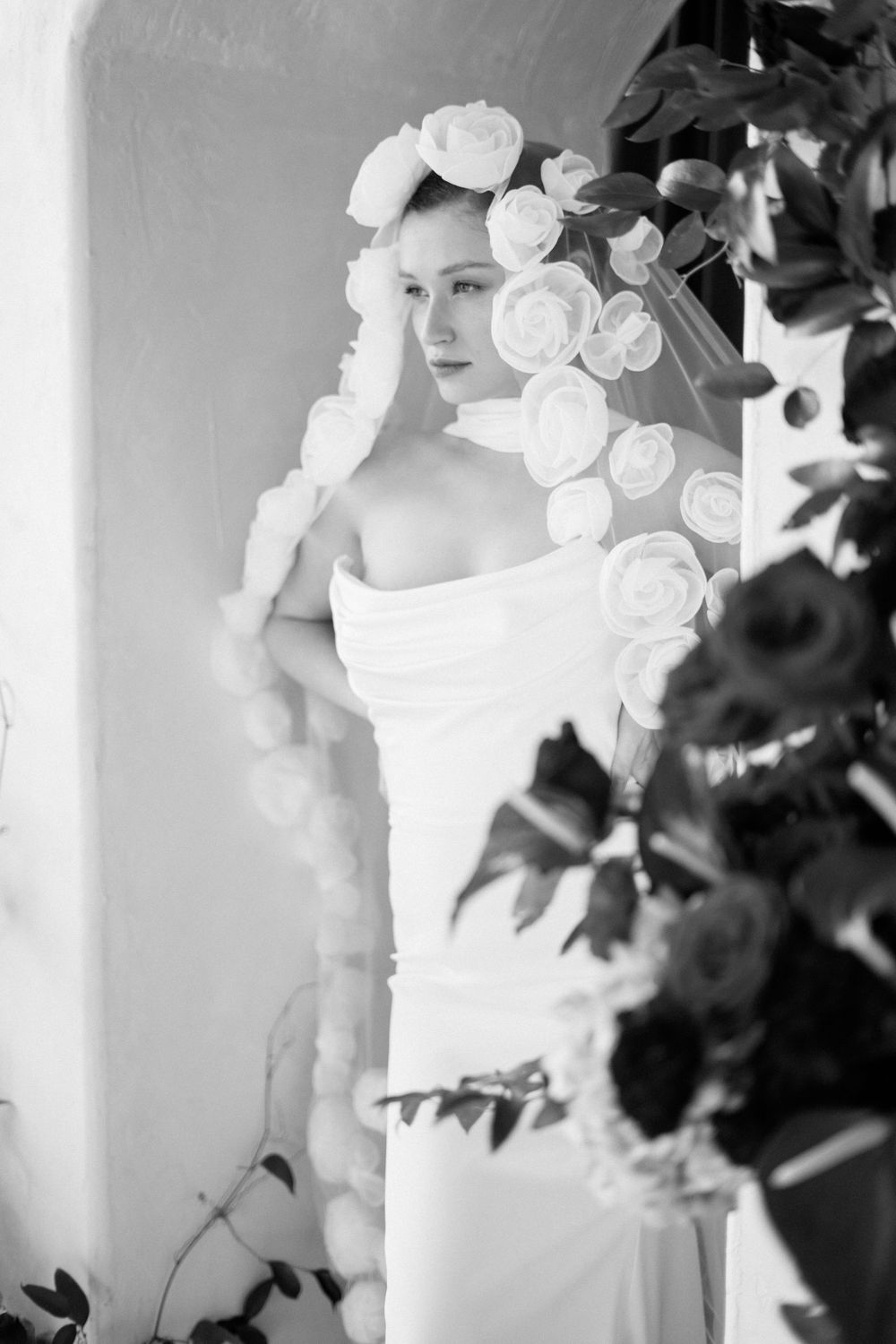 Black and white artistic wedding photo series showing elegant white floral details and romantic bridal silhouettes.