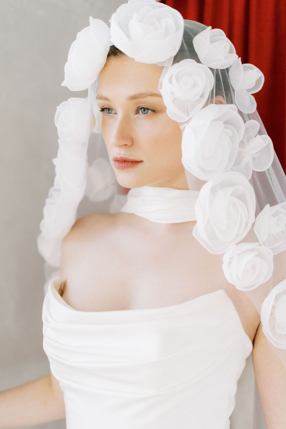 Bridal fashion detail featuring white fabric roses and delicate design elements.