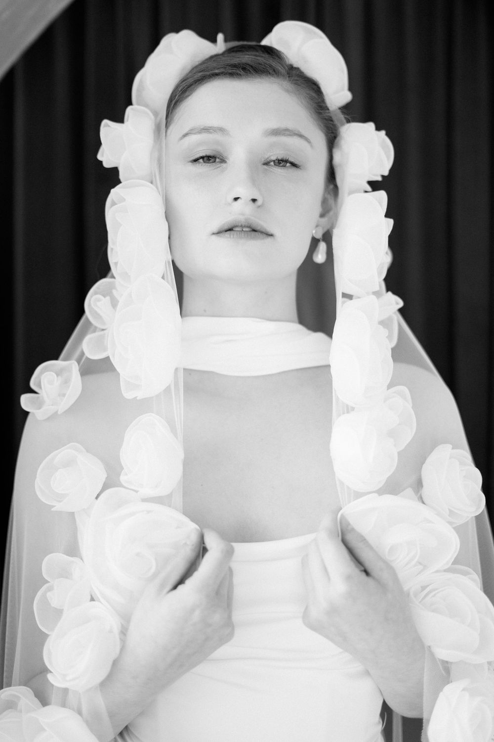 Series of artistic black and white portraits featuring white floral accessories and dramatic lighting.