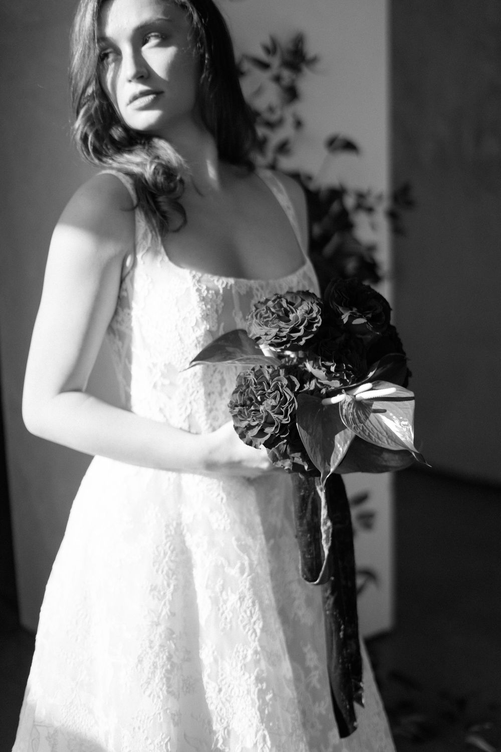 A series of dramatic black and white bridal portraits showcasing a white lace wedding dress and romantic styling.