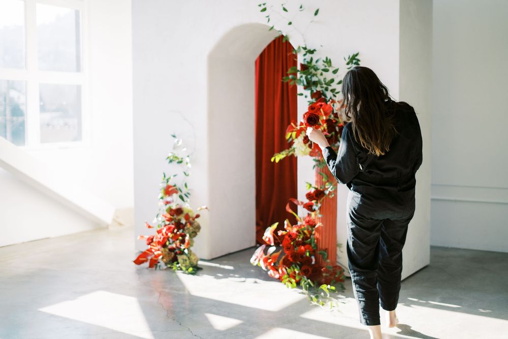 Sunlit white interior room with burgundy door trim and decorative floral elements.