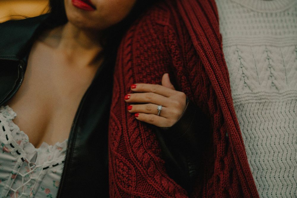Close-up details of burgundy knit sweater and dark hair against a white background.