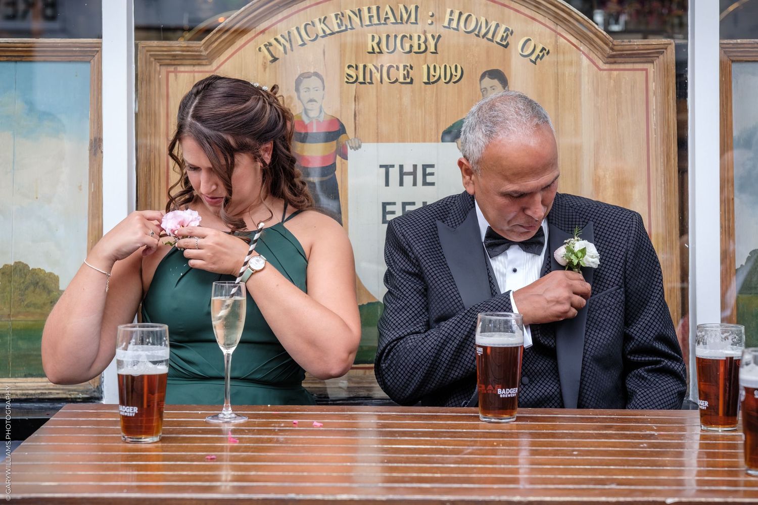 Wedding party seated at the head table raises glasses in a celebratory toast during the reception.