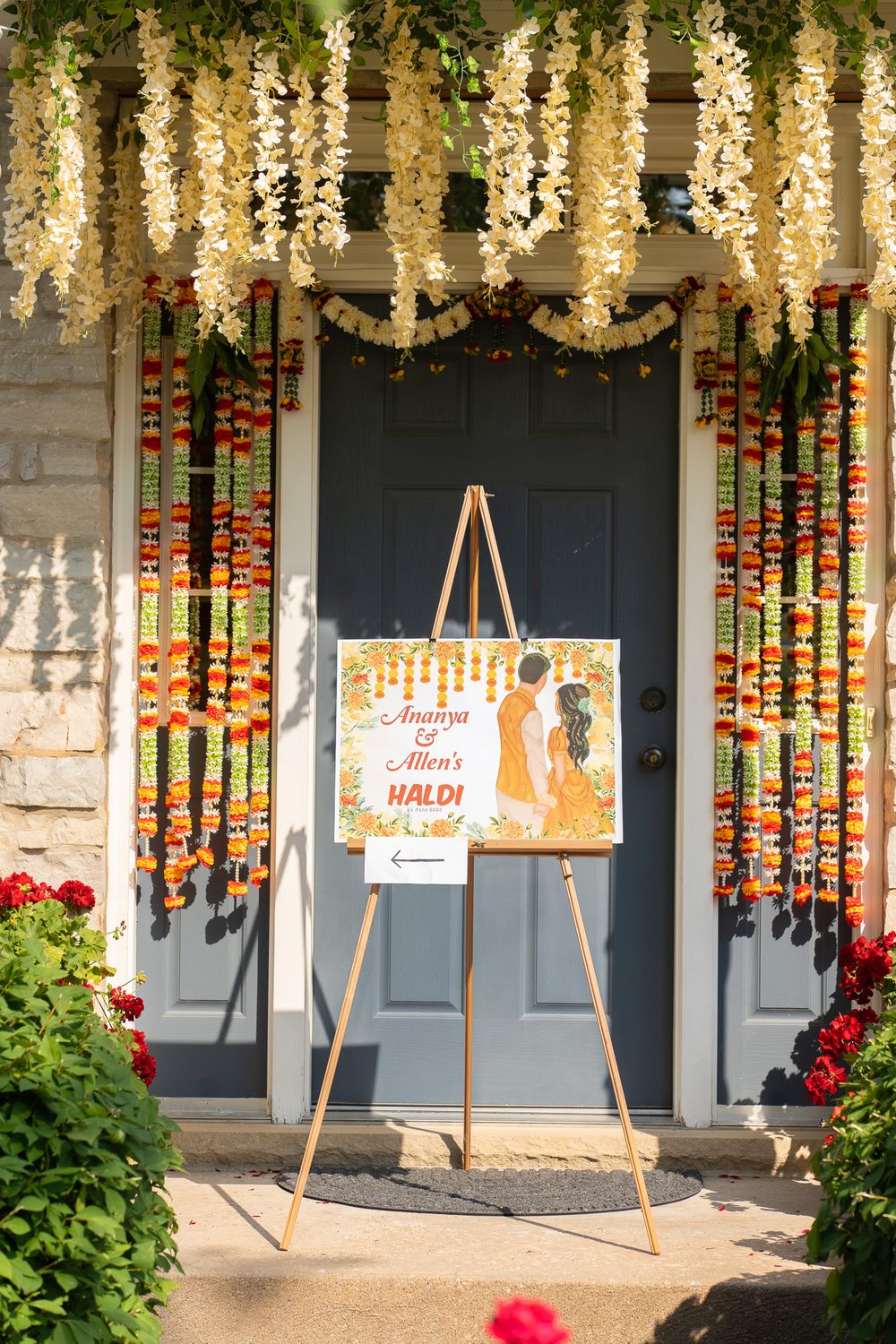 Storefront window decorated with hanging lights, colorful floral garlands. Haldi Quad Cities Photography