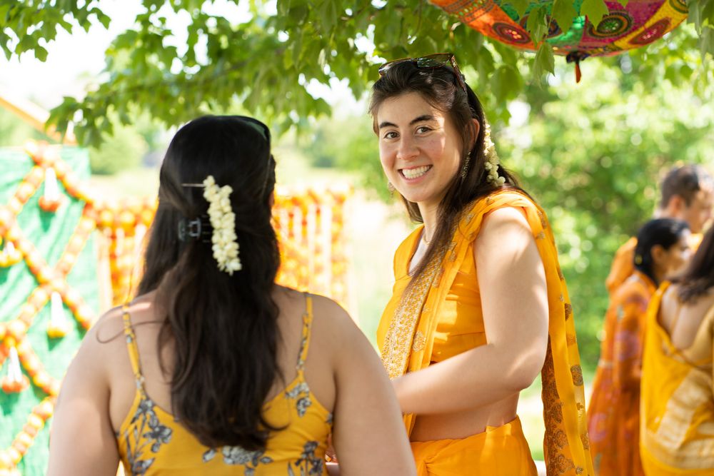 A vibrant haldi ceremony celebration with people in yellow outfits and colorful decorations gathered outdoors. Haldi Quad Cities Photography