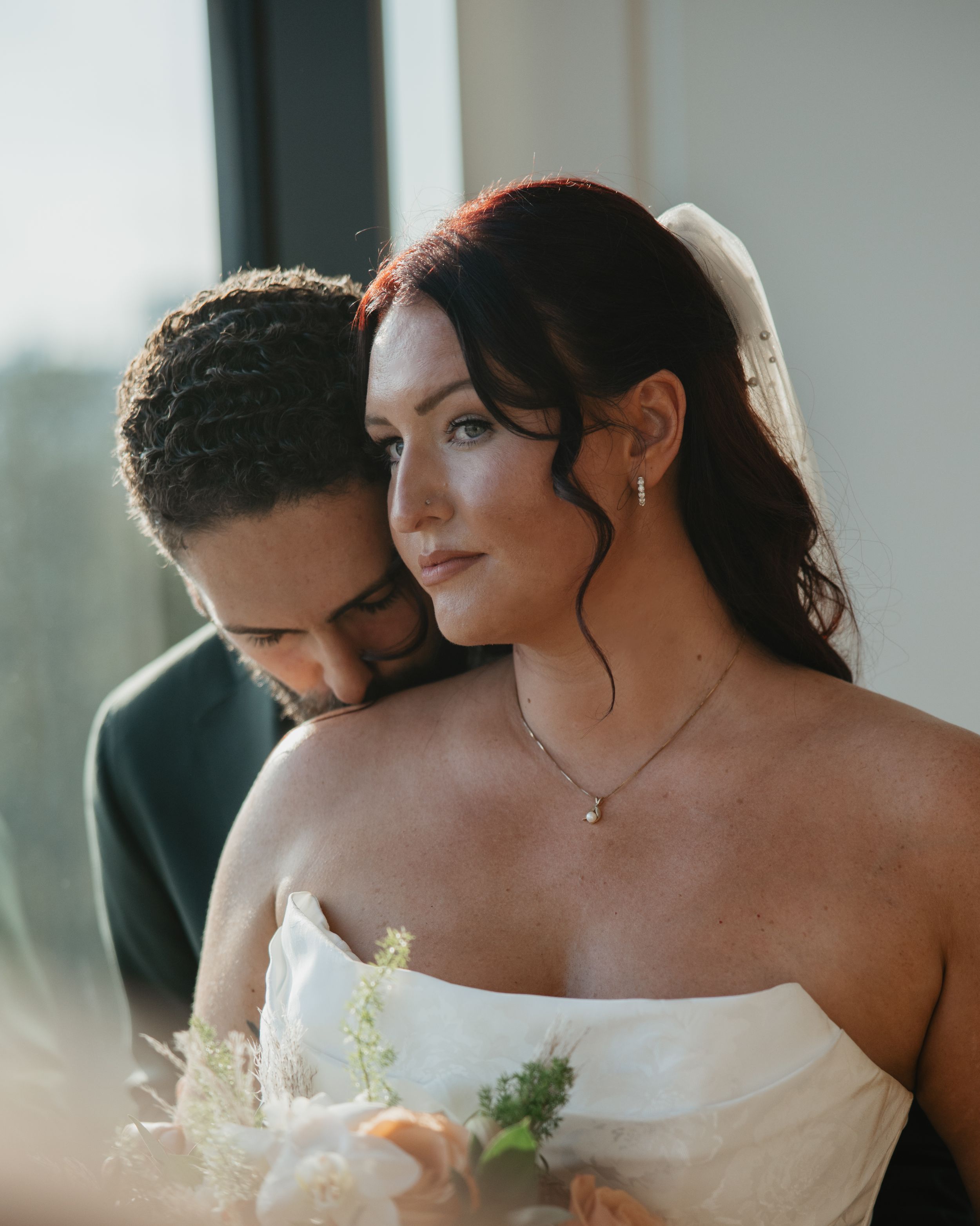 A romantic wedding moment captured in a series of intimate poses against a bright window backdrop.