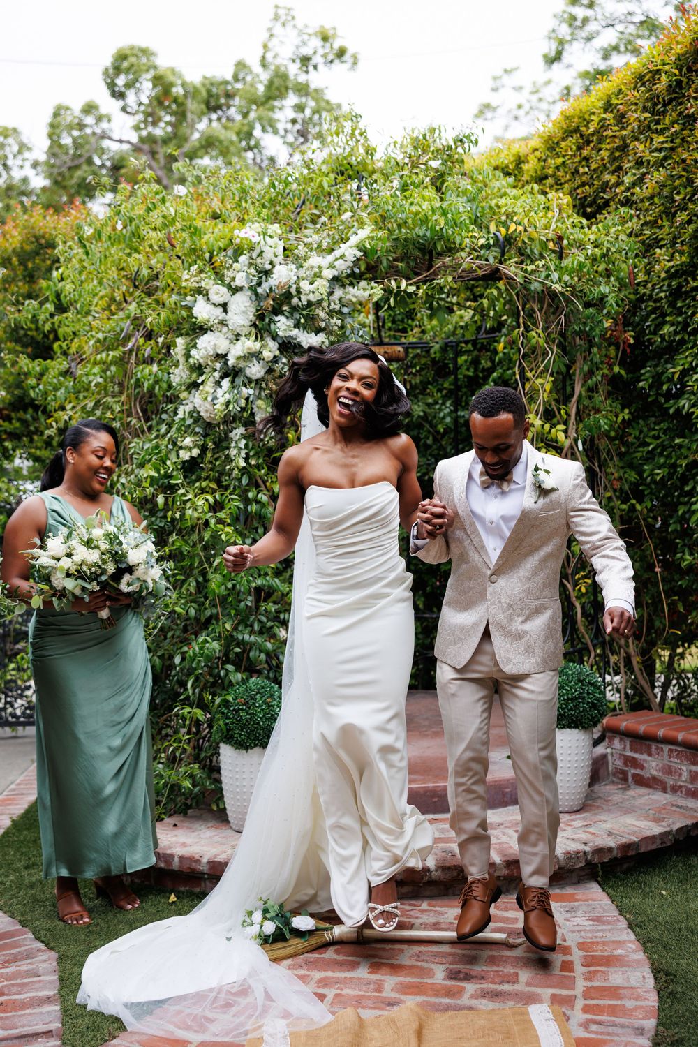 Wedding couple celebrating their marriage together at Chapel of Orange by lush garden greenery on a sunny day.