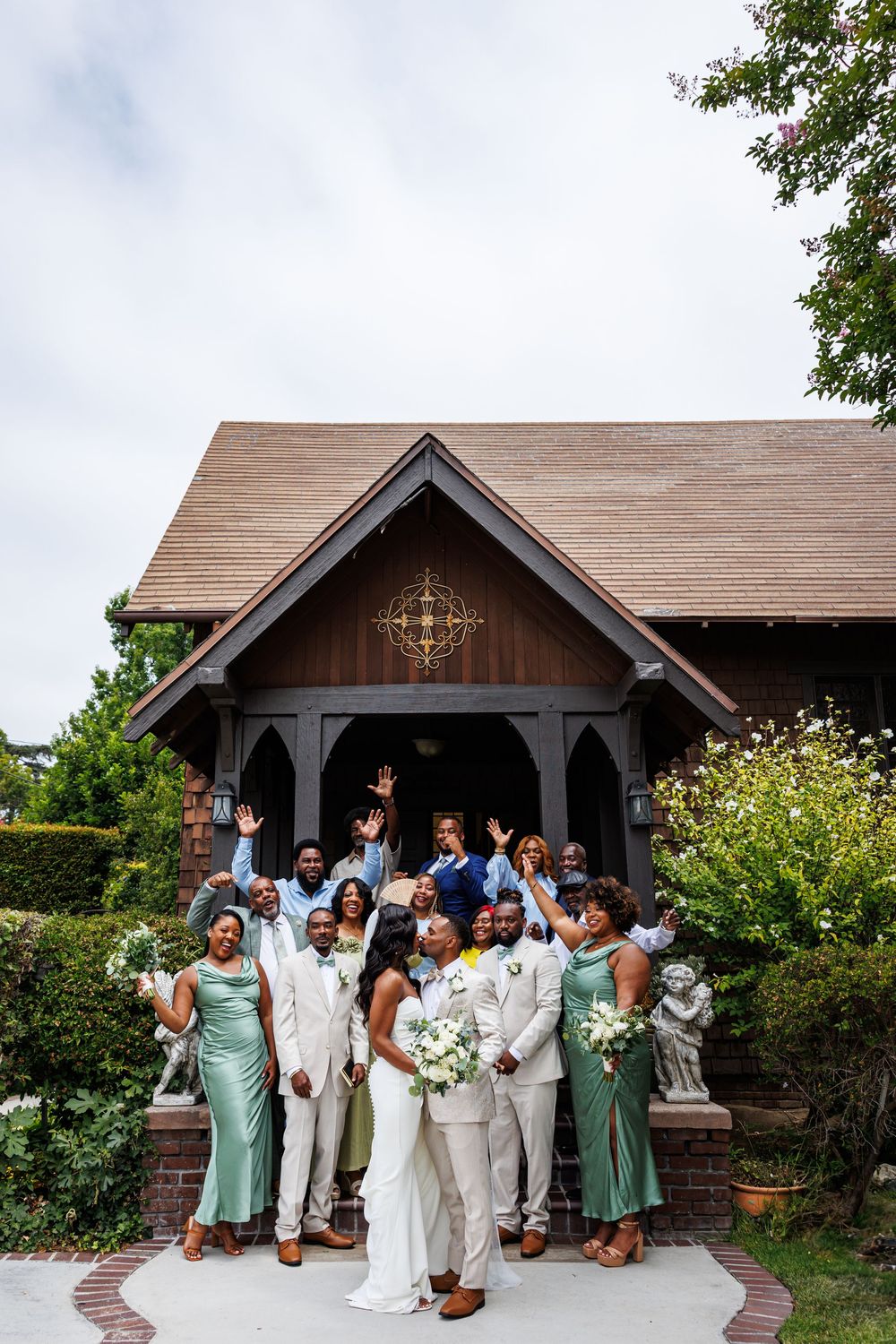 Wedding party poses outdoors at a Chapel of Orange during a celebratory group photo moment.