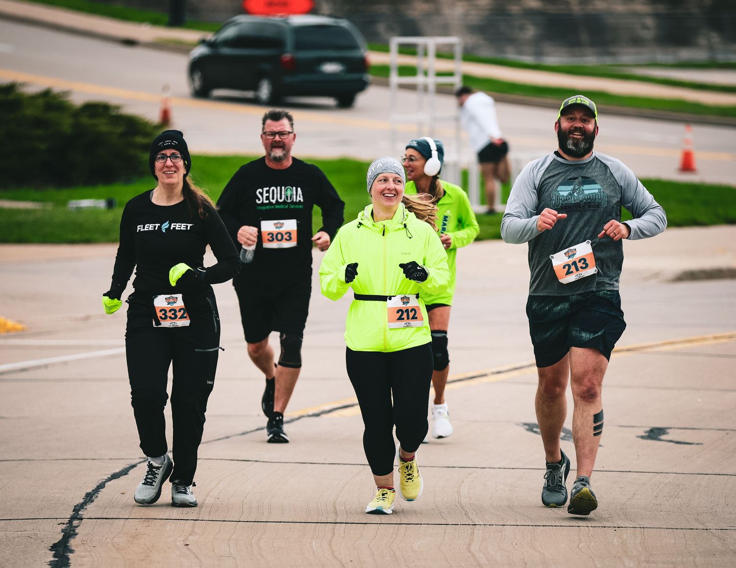 Participants running along a marked course during an outdoor community race or fitness event.