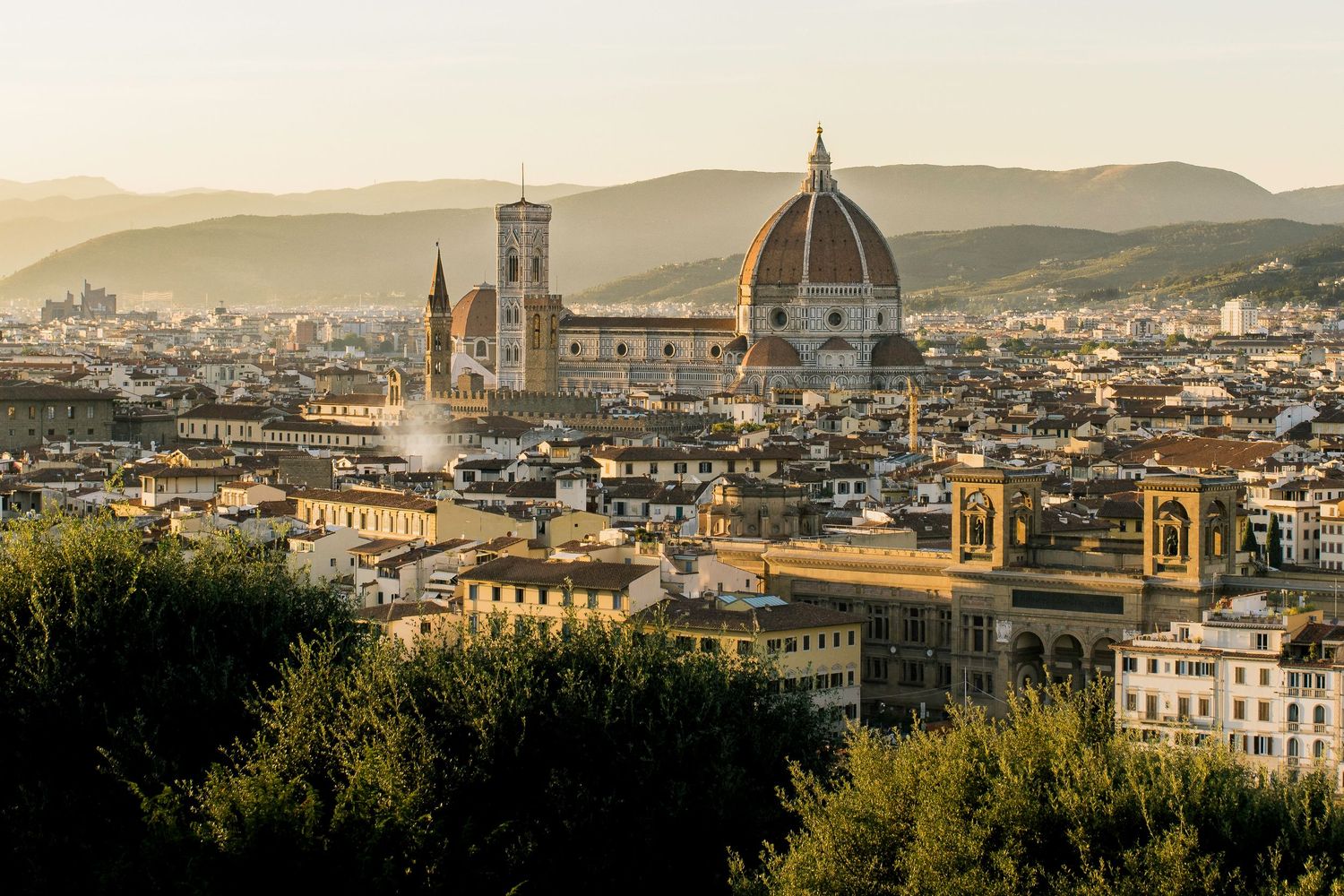 photo of the skyline of the city of Florence with the Duomo in the middle at sunset.