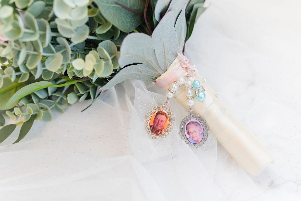 Delicate pink and crystal bridal earrings displayed on white tulle fabric with eucalyptus leaves in the background.