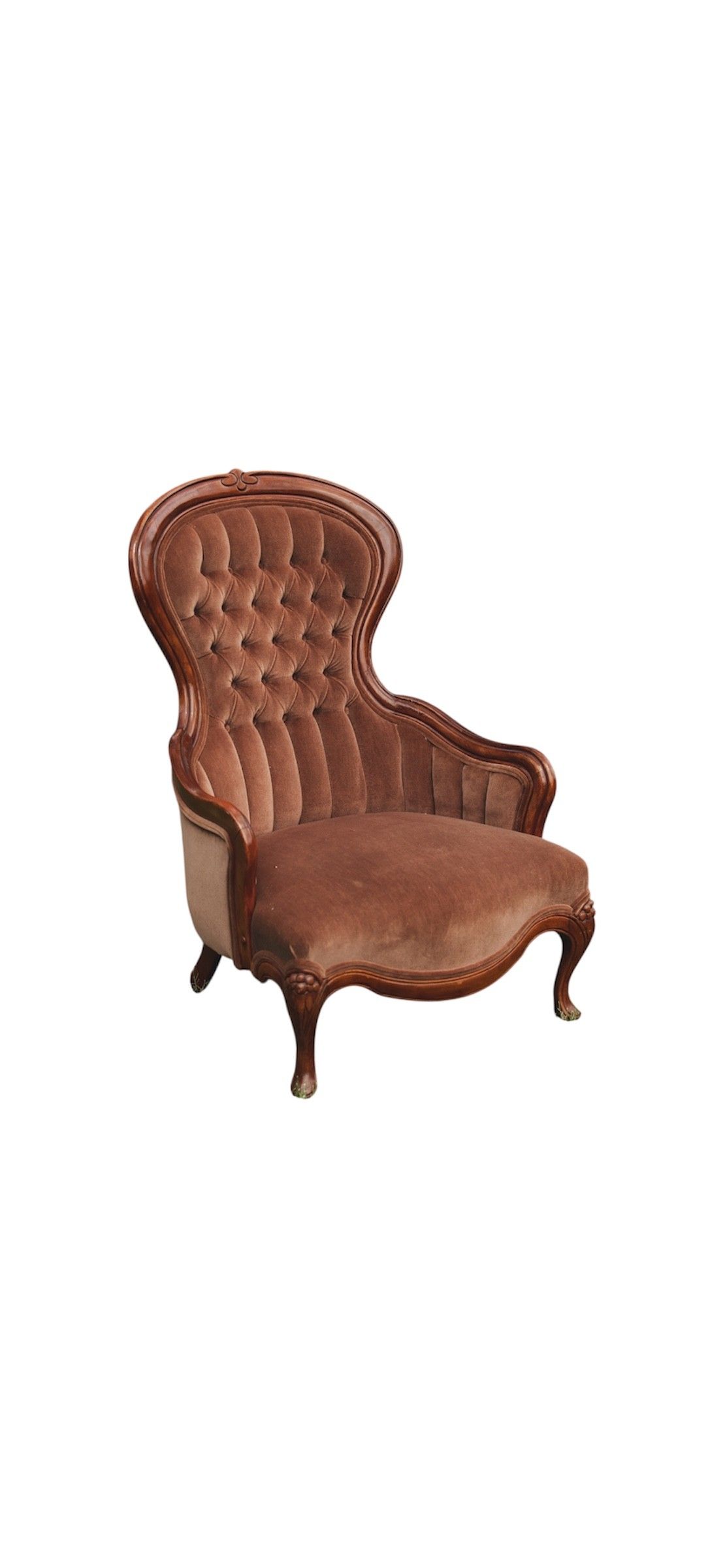 Victorian style velvet armchair in dusty pink with button tufting sits on green grass against trees outdoors.