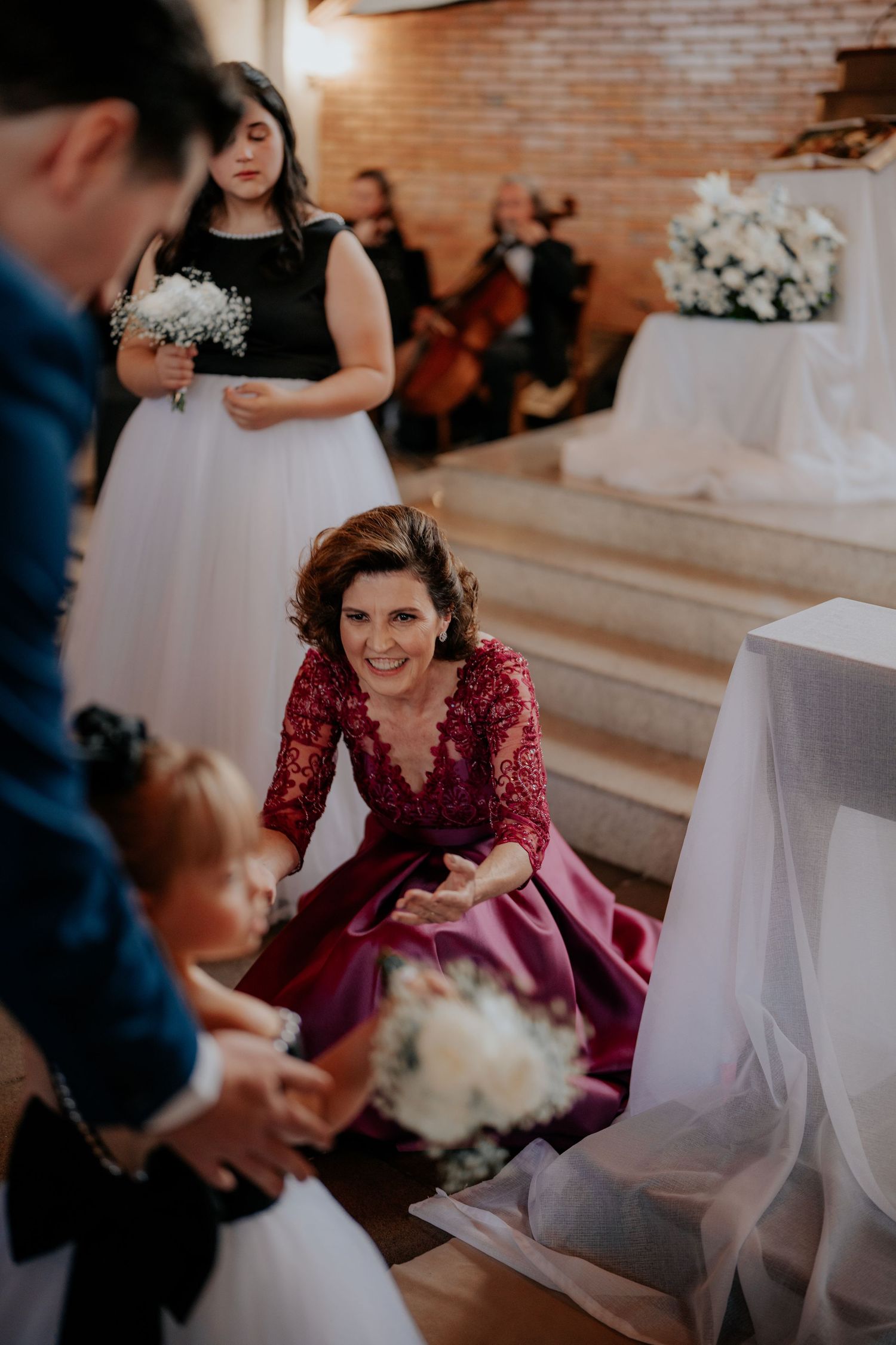 Wedding celebration inside venue with brick walls and white decorations.
