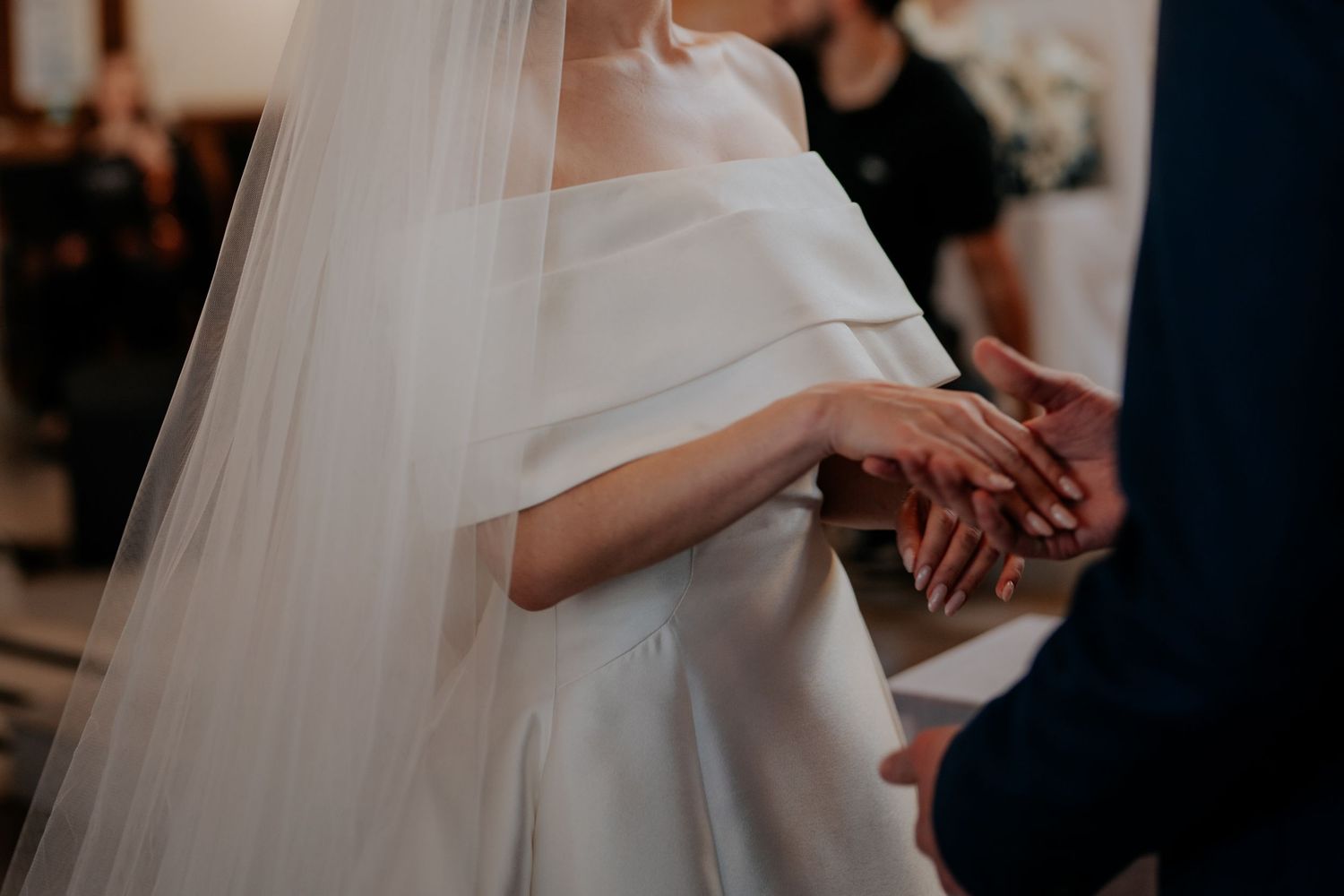Close-up shot of a bride and groom's hands during their wedding ceremony.