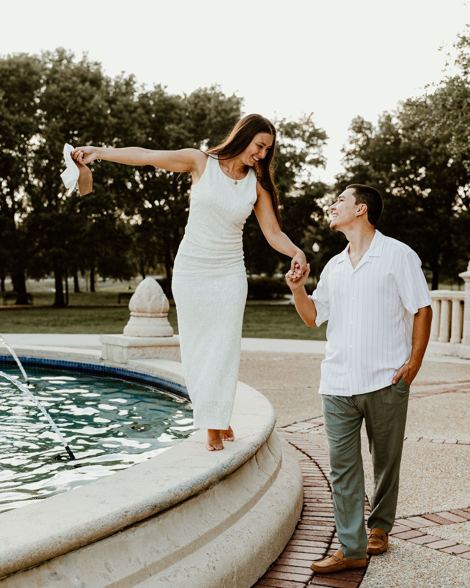 Couple shares intimate moment by a swimming pool at sunset.