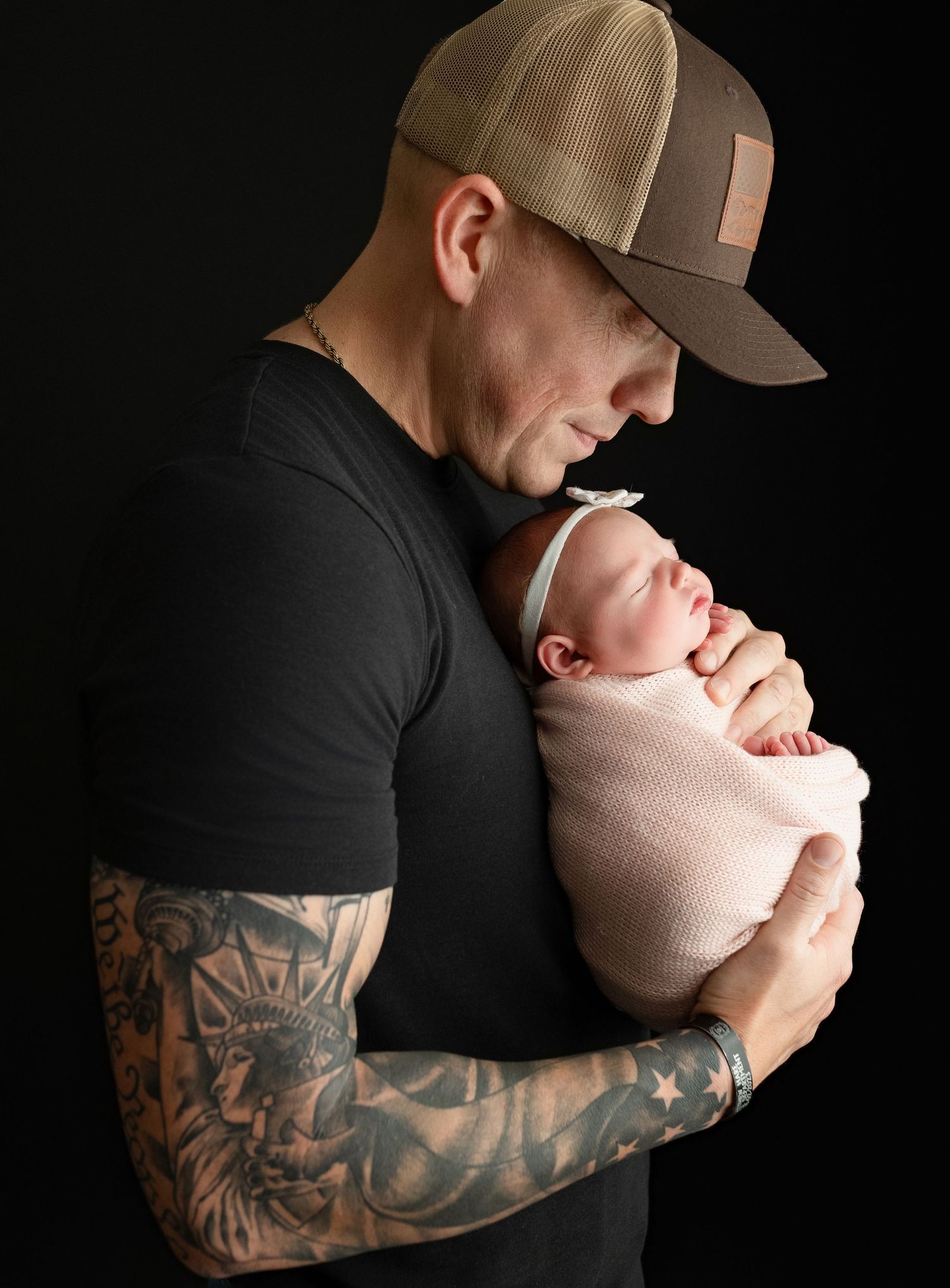 Dad is holding the newborn baby girl very tenderly. - Greenville SC newborn photographer - Easley SC newborn photographer