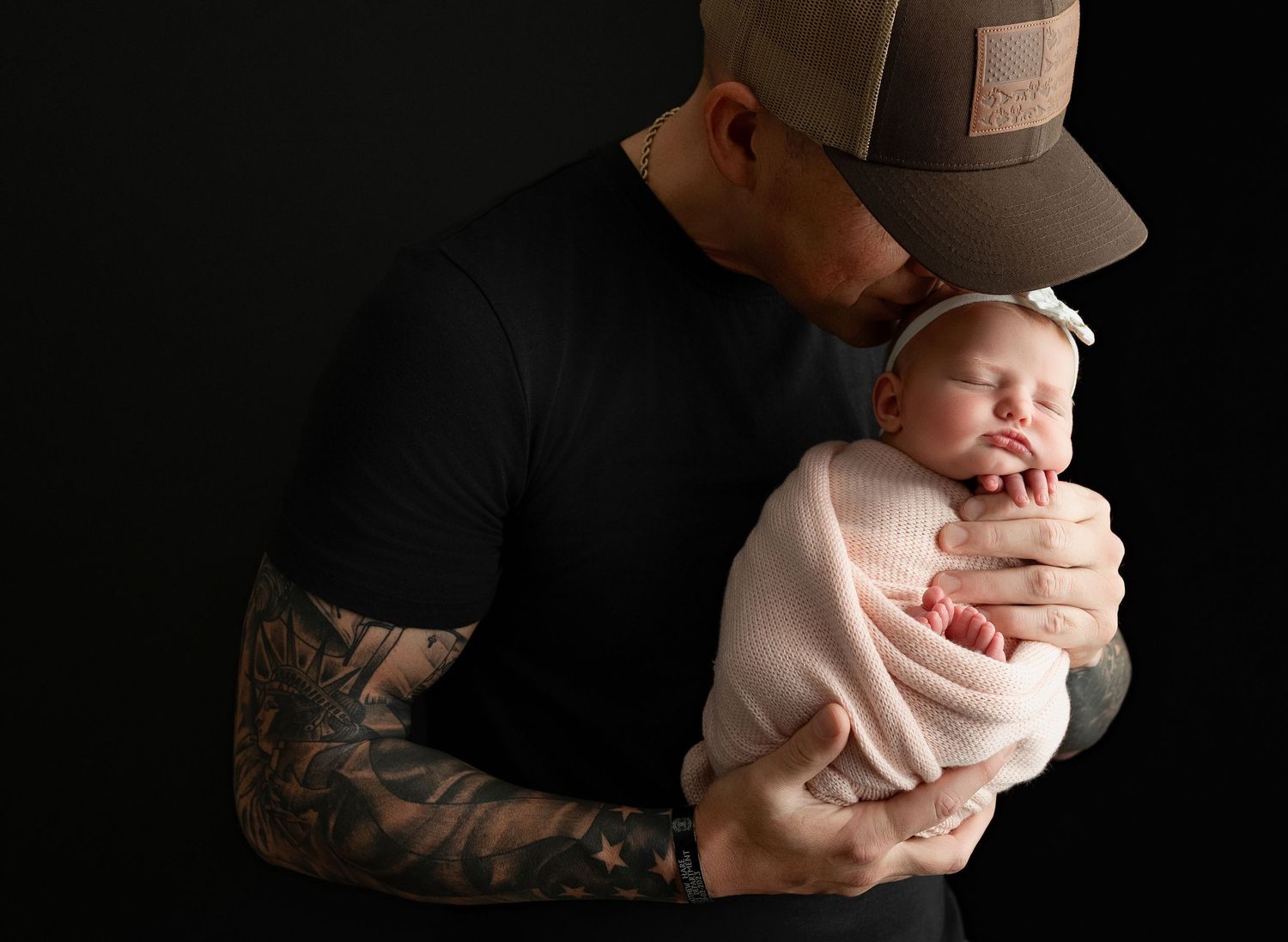 Dad is holding the newborn baby girl very tenderly. - Greenville SC newborn photographer - Easley SC newborn photographer