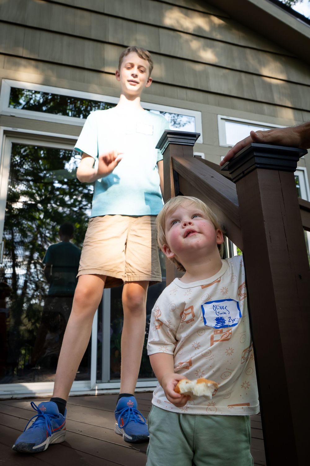 A child in a beige shirt and khaki shorts jumping and playing with joyful expressions