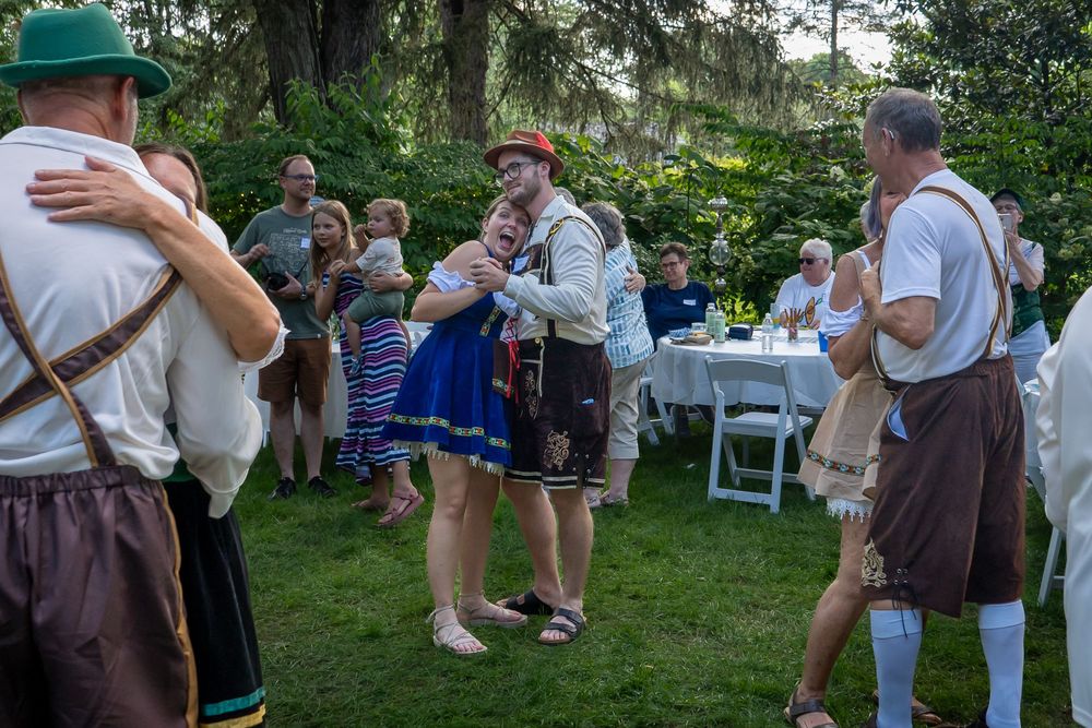 People gathered and dancing for an outdoor party in a lush garden setting.