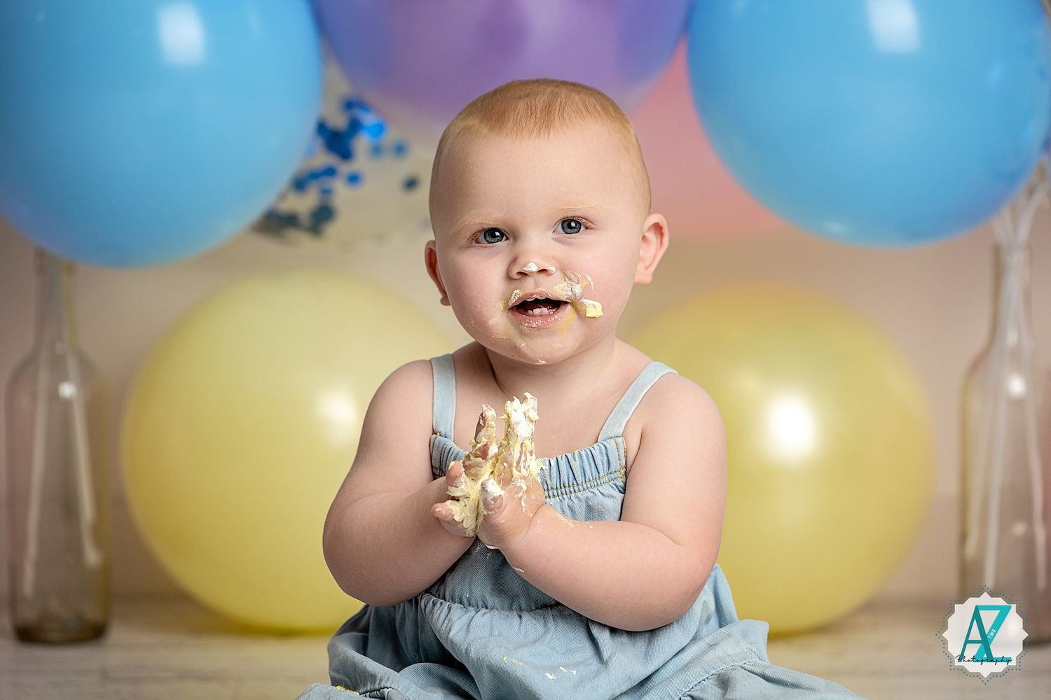 Festive first birthday scene with colorful balloons and decorative setup.
