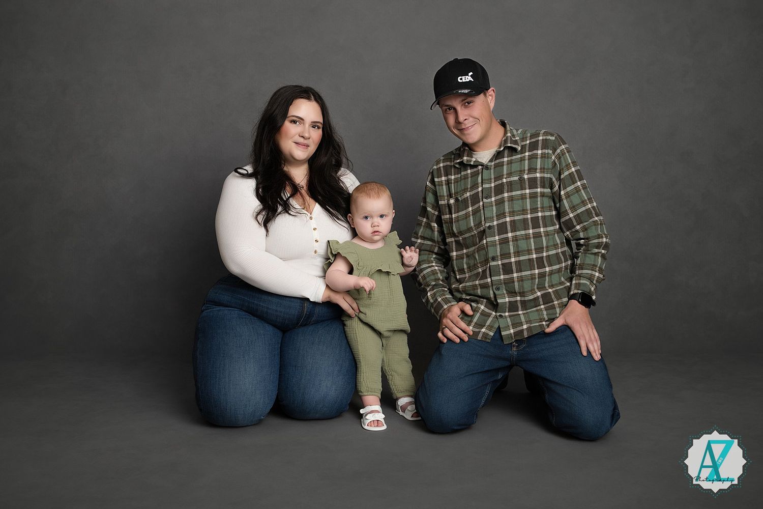 Studio family portrait against dark grey background with casual attire.
