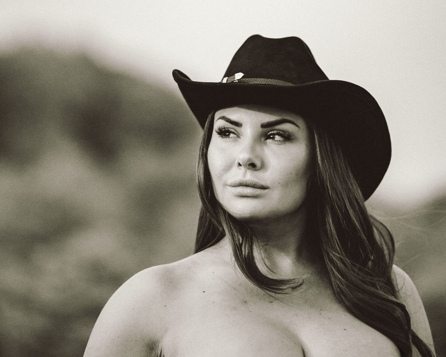 Cowgirl porträtt i svartvitt – kvinna i cowboyhatt och bustier med intensiv blick | Porträttfotograf Malmö