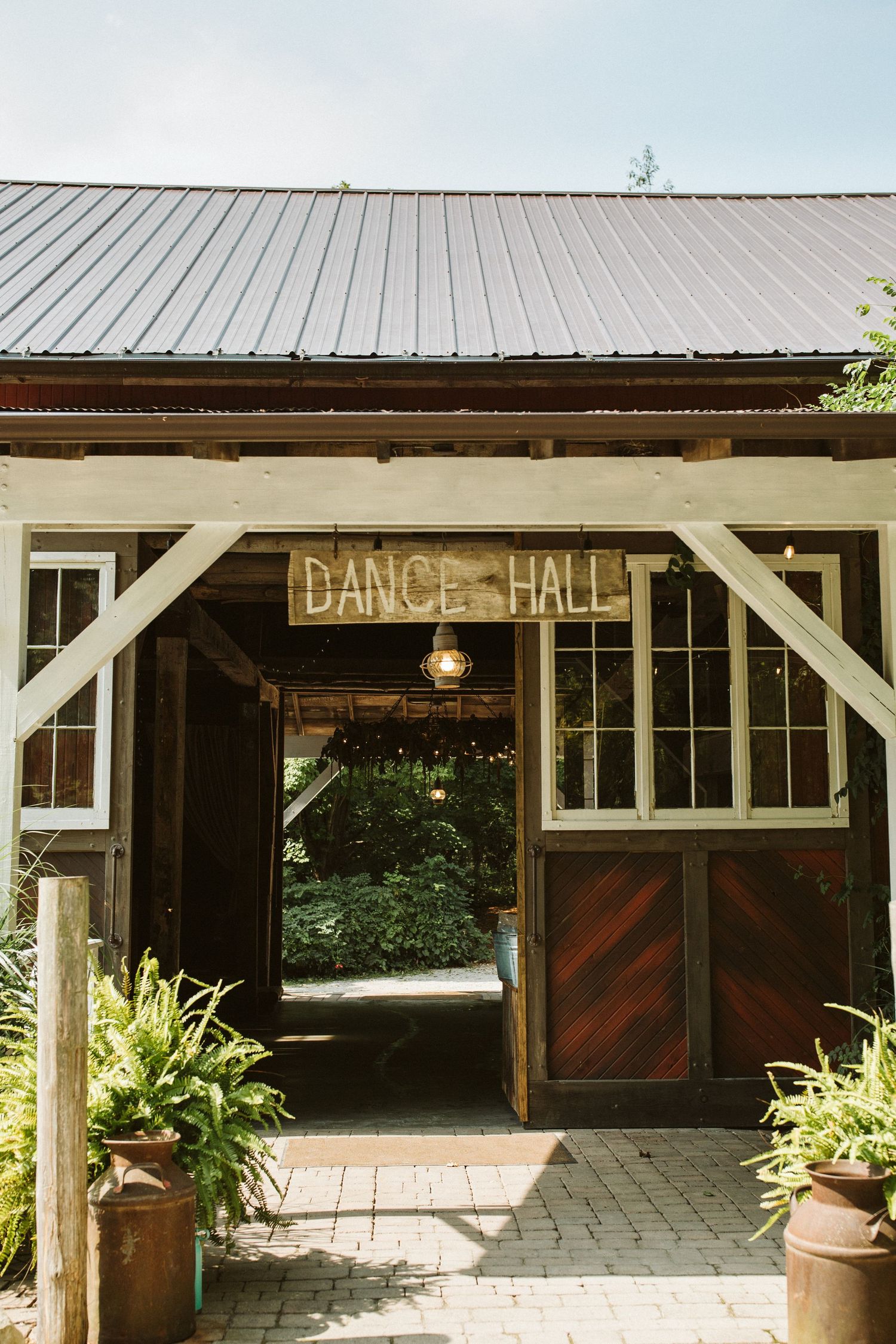 Rustic dance hall exterior with white posts and wooden doors.