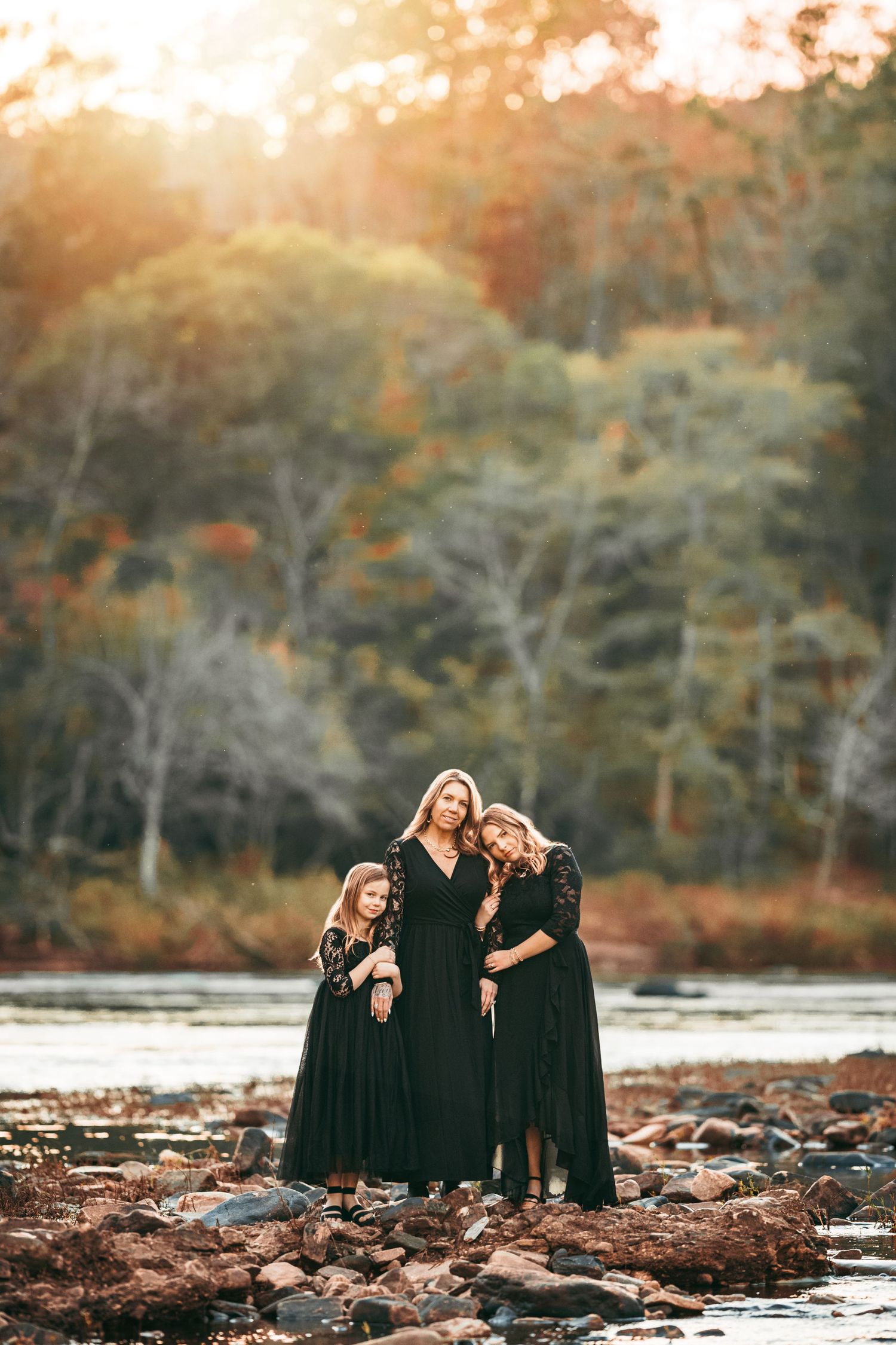A group of people in casual fall clothing sitting together on the grass during an autumn photoshoot.