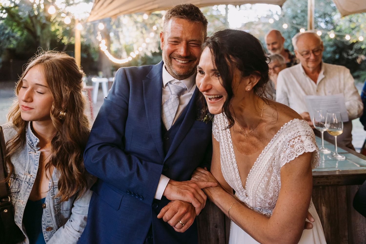 Joyful wedding celebration at an outdoor venue with festive dancing and natural lighting.